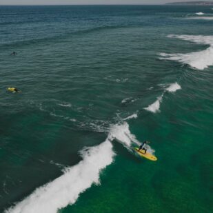 Drohnenaufnahme einer Person, die in Costa Rica auf einer Welle surft