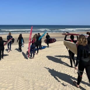 Surfkurs für Anfänger während eines Surftrips im Van