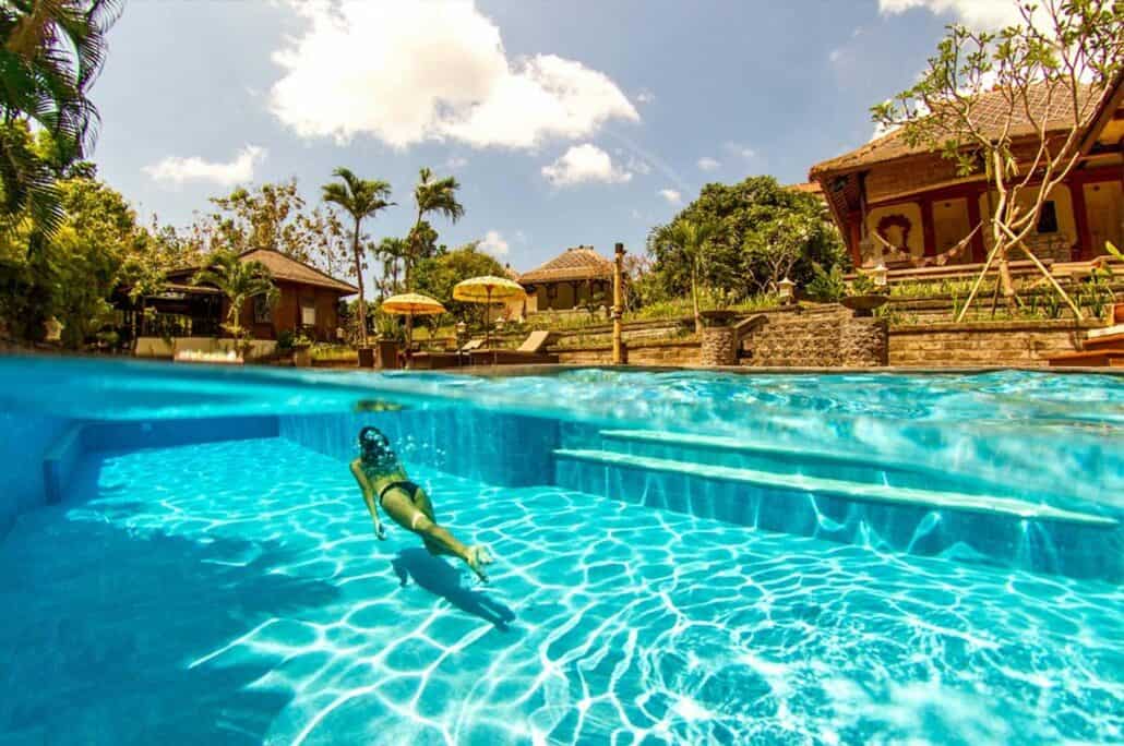 Swimmingpool mit Schwimmerin eines Surfcamps