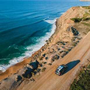 Surf spot on the edge of a cliff in Portugal with a car driving over the cliff