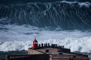 Wave of Nazaré over Portugal's red lighthouse