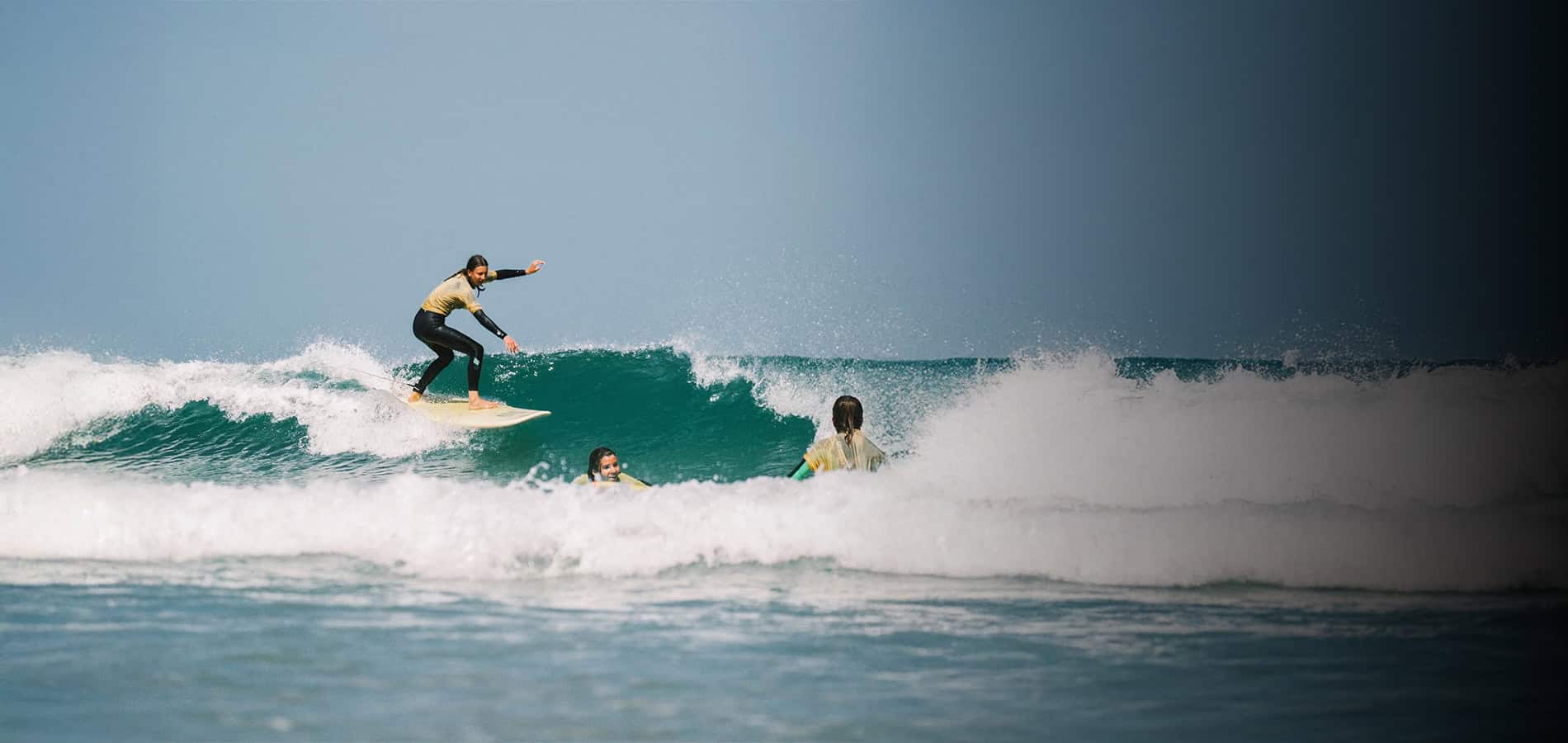 Banner mit einer Intermediate-Surferin während eines Surfkurses in Spanien
