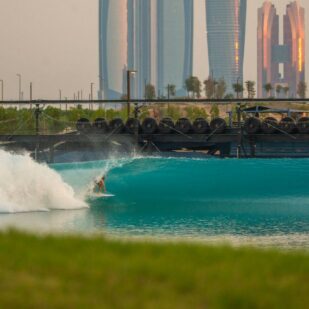 Artificial wave with a jet-ski and a surfer in Abu Dhabi, with the skyscrapers in the background