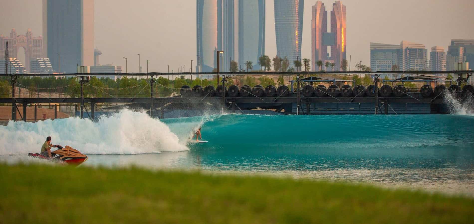 Artificial wave with a jet-ski and a surfer in Abu Dhabi, with the skyscrapers in the background